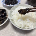 お箸で持ち上げた、しじみ入りのり佃煮のシズル感ある写真。海苔としじみエキスの濃厚さが伝わる、購入を後押しする食欲喚起イメージ。