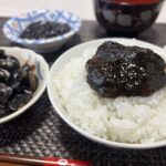 炊きたての白いご飯に乗せたしじみ入りのり佃煮と、傍らに添えられた新鮮な宍道湖産しじみのイメージ写真。素材の良さと食欲をそそる盛り付け。