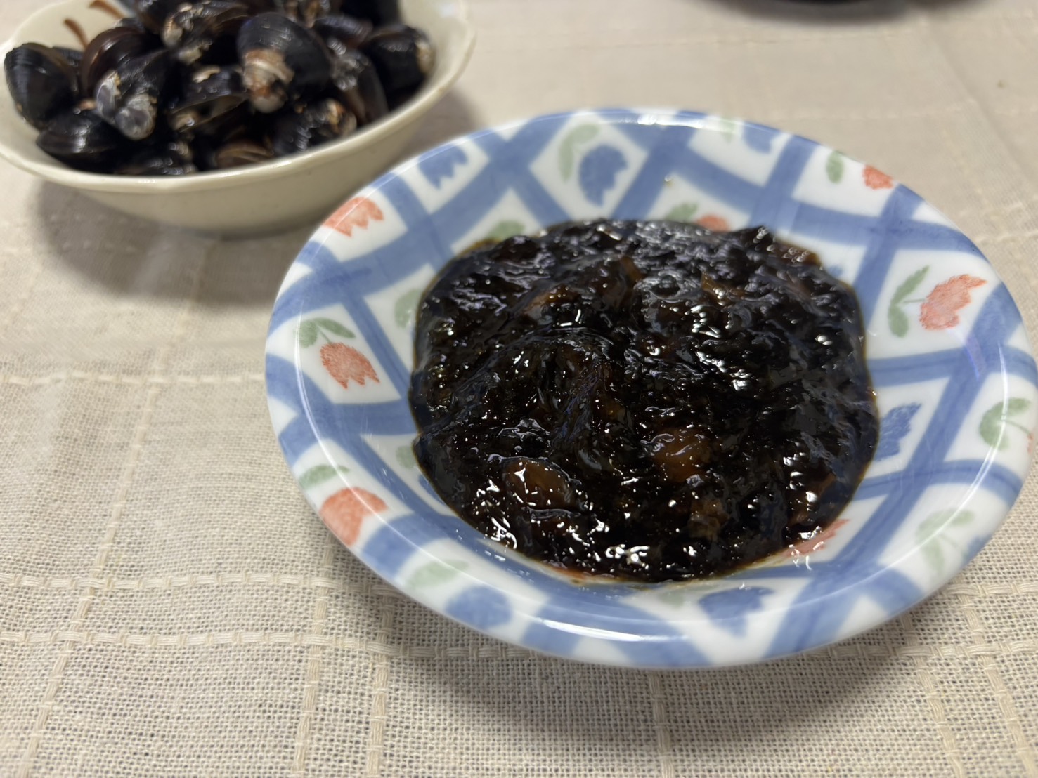 小皿に盛り付けられた、しじみ入りのり佃煮のアップ写真。ほんのり甘口で艶やかな質感の佃煮。