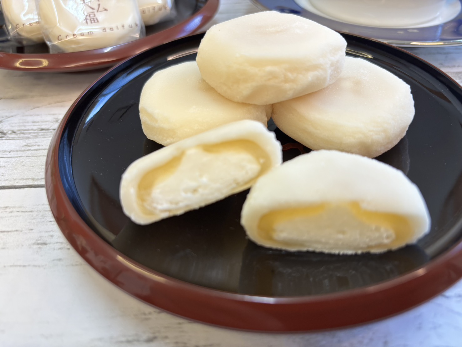 半分にカットされた大山ヨーグルトクリーム大福の断面。中心のホイップクリームとヨーグルト餡、外側のお餅が織りなす「とろりと美味しそうな三層構造」のアップ写真。