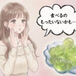 女性がシャインマスカット玉ゼリーを指でつまみ 食べるか迷っているシーン